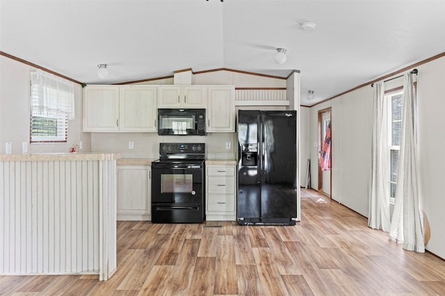 kitchen featuring vaulted ceiling, black appliances, white cabinets, light wood-type flooring, and ornamental molding