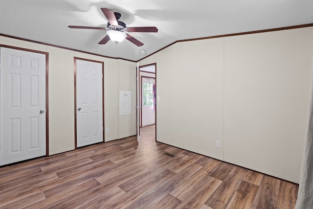 unfurnished bedroom featuring crown molding, vaulted ceiling, ceiling fan, and hardwood / wood-style floors