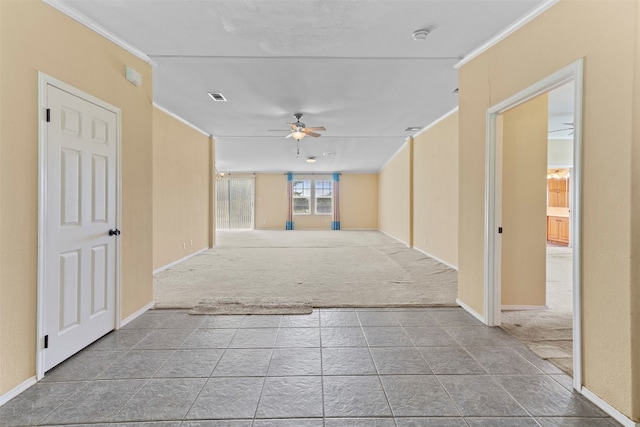 spare room with ornamental molding, ceiling fan, and dark tile floors