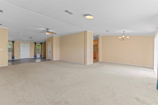 carpeted spare room with ceiling fan with notable chandelier, ornamental molding, and vaulted ceiling