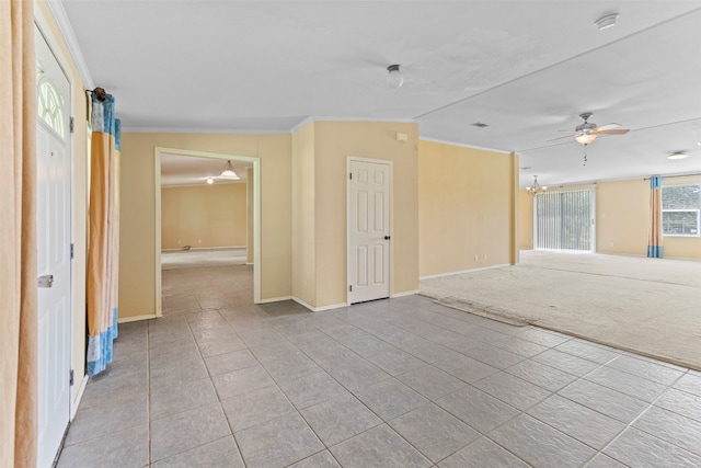 empty room featuring crown molding, light carpet, and ceiling fan