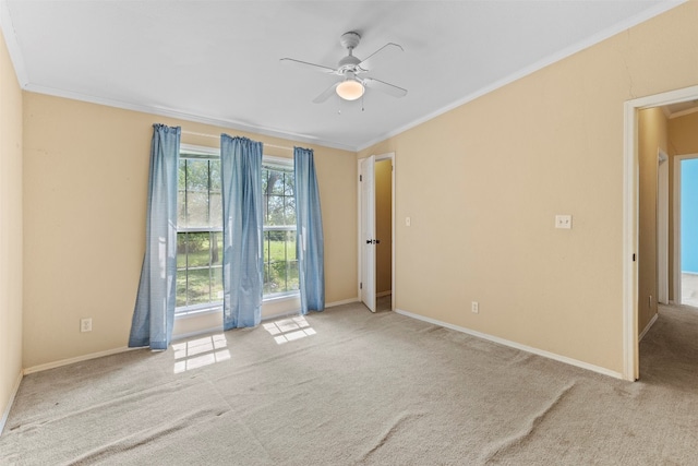 unfurnished room featuring light colored carpet, ceiling fan, and crown molding