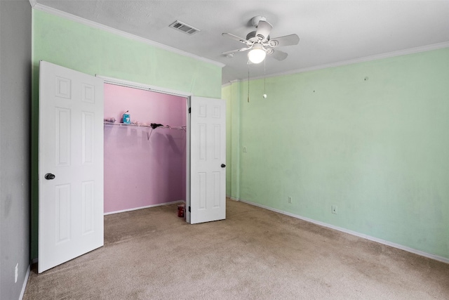 unfurnished bedroom with ornamental molding, light carpet, and ceiling fan