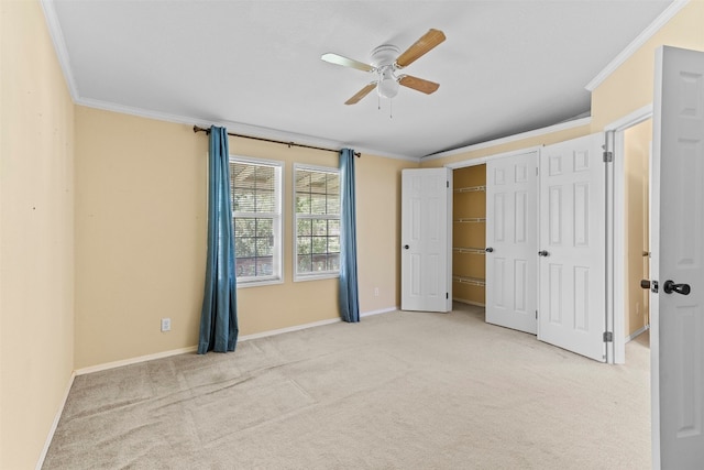 interior space with ornamental molding, light colored carpet, and ceiling fan