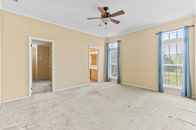 carpeted empty room featuring plenty of natural light, crown molding, and ceiling fan