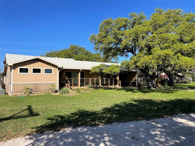 view of front of house with a front yard and central air condition unit