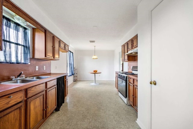 kitchen with hanging light fixtures, white range with gas stovetop, a textured ceiling, sink, and light tile floors