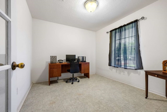 office area featuring light tile flooring and a textured ceiling