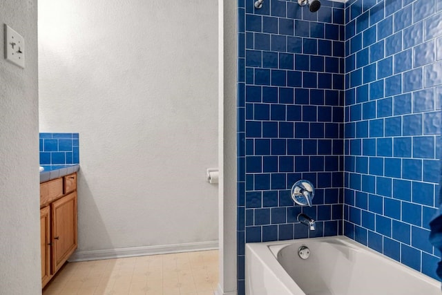 bathroom with vanity, tiled shower / bath, and tile flooring