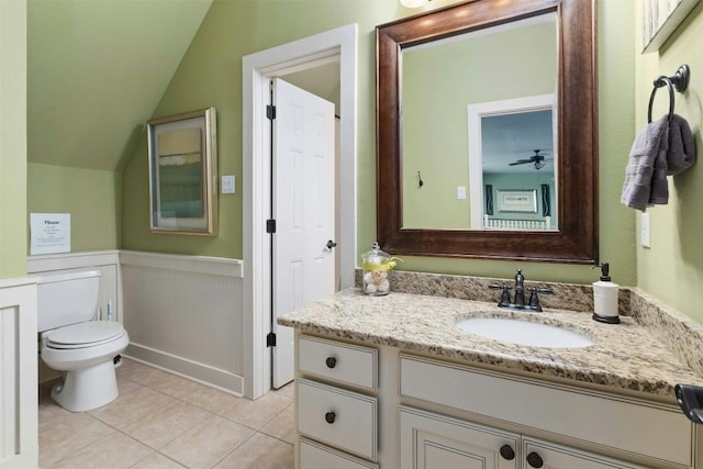 bathroom with tile floors, toilet, oversized vanity, and lofted ceiling