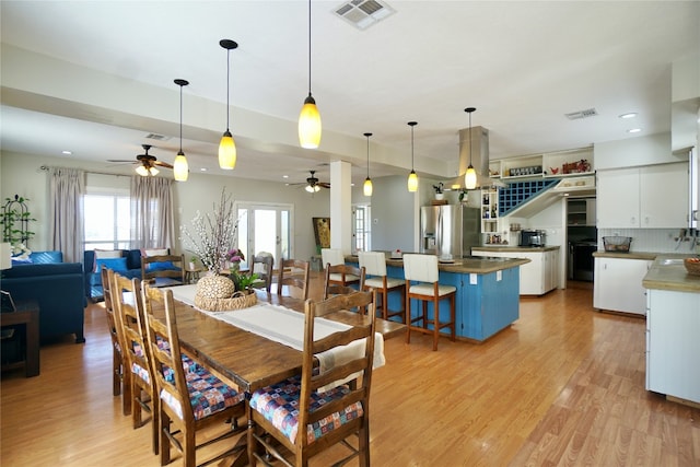 dining space with sink, light wood-type flooring, and ceiling fan