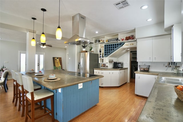 kitchen featuring black electric cooktop, white cabinetry, tasteful backsplash, stainless steel refrigerator with ice dispenser, and island range hood