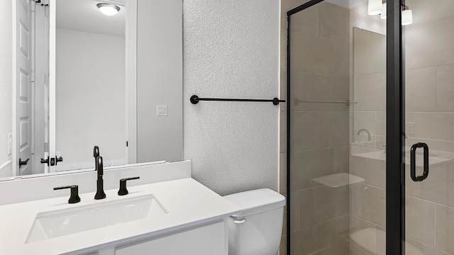 bathroom with walk in shower, vanity, and toilet