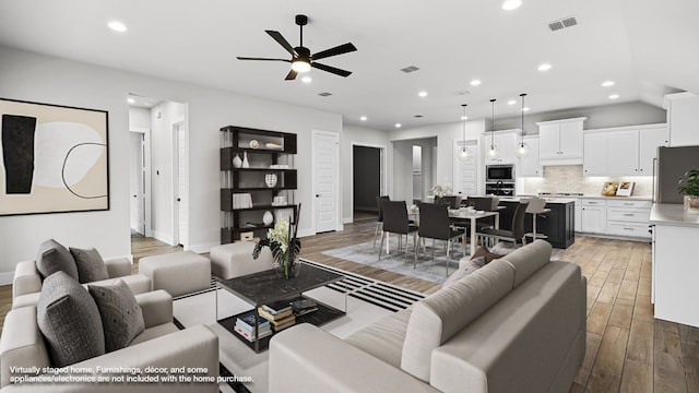 living room with ceiling fan and light hardwood / wood-style flooring