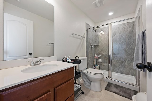 bathroom featuring vanity, toilet, visible vents, and a stall shower