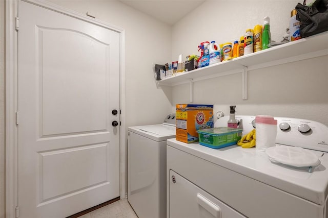 clothes washing area featuring light tile patterned flooring, laundry area, and washer and clothes dryer