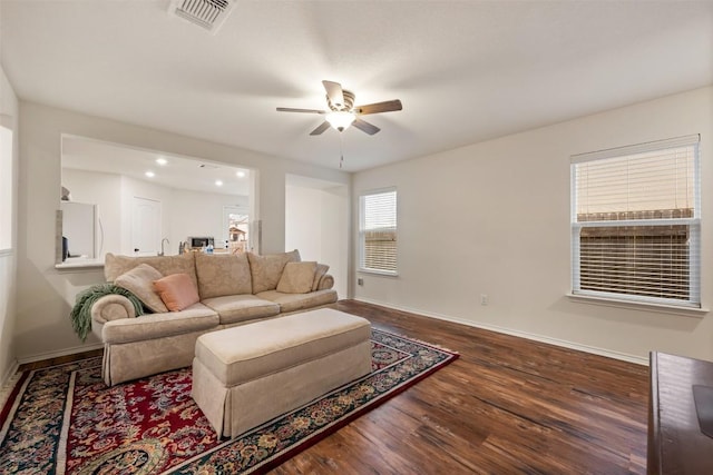 living area with visible vents, baseboards, a ceiling fan, and wood finished floors