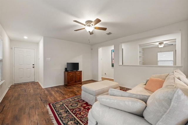 living room with wood finished floors, a ceiling fan, visible vents, and baseboards