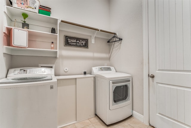 laundry room featuring separate washer and dryer, light tile flooring, and electric dryer hookup