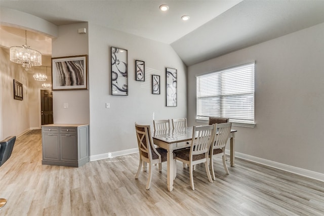 dining area featuring lofted ceiling, a chandelier, and light wood-type flooring