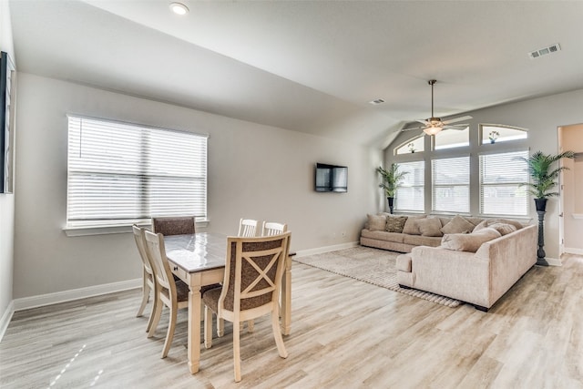 dining area with vaulted ceiling, ceiling fan, and light wood-type flooring