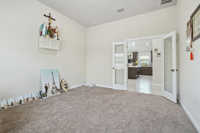 carpeted spare room featuring french doors