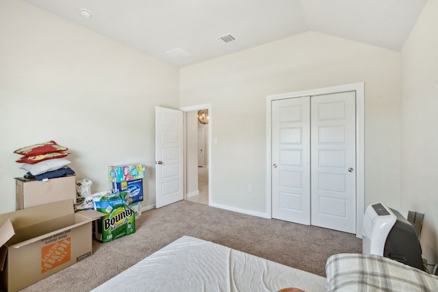 bedroom featuring a closet, vaulted ceiling, and light carpet