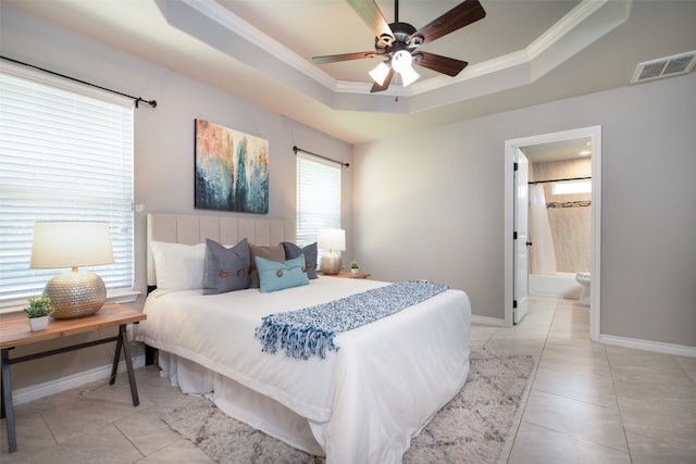 tiled bedroom with crown molding, connected bathroom, ceiling fan, and a raised ceiling