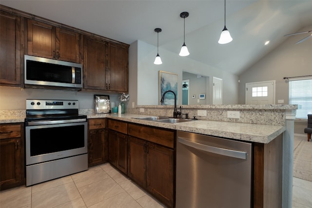 kitchen featuring pendant lighting, appliances with stainless steel finishes, vaulted ceiling, and light tile flooring