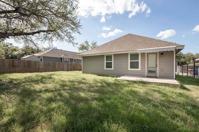 rear view of property with a yard and a patio area