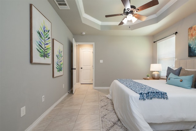 bedroom with ornamental molding, ceiling fan, light tile floors, and a tray ceiling