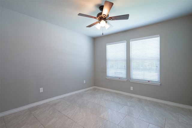 unfurnished room with ceiling fan and light tile flooring