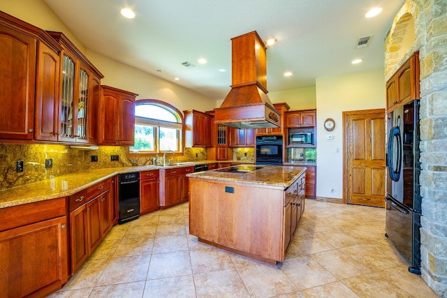 kitchen with black appliances, tasteful backsplash, a center island, custom exhaust hood, and light stone counters