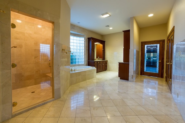 bathroom with vanity, separate shower and tub, and tile walls