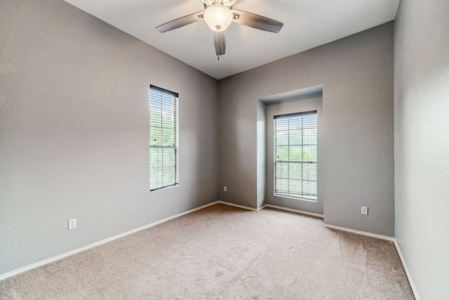 unfurnished room featuring light colored carpet and ceiling fan