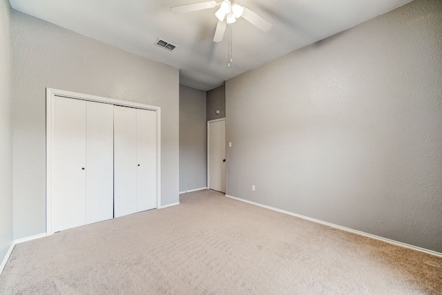 unfurnished bedroom featuring a closet, ceiling fan, and light carpet