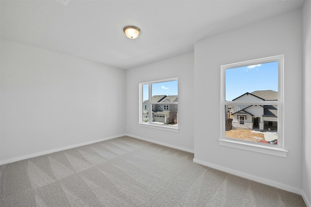 carpeted spare room featuring a healthy amount of sunlight