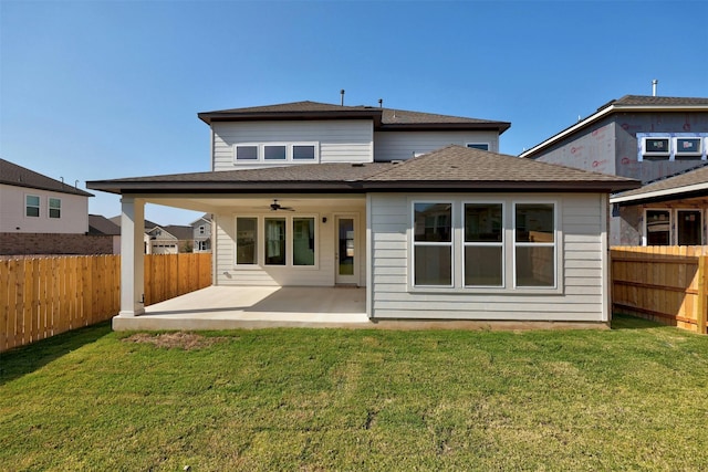 back of property with a yard, a patio area, and ceiling fan