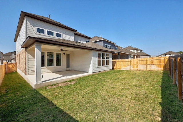 rear view of property with ceiling fan, a patio, and a lawn