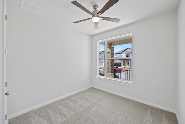 carpeted spare room featuring ceiling fan