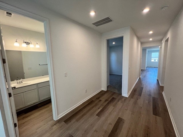 corridor featuring sink and dark wood-type flooring