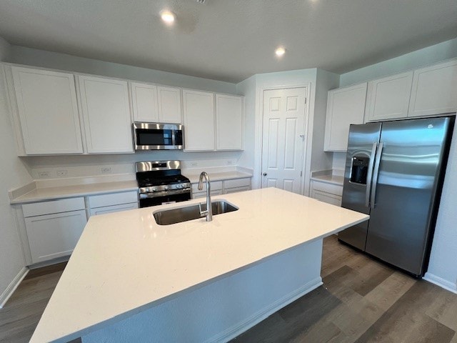 kitchen featuring stainless steel appliances, a center island with sink, and dark hardwood / wood-style floors