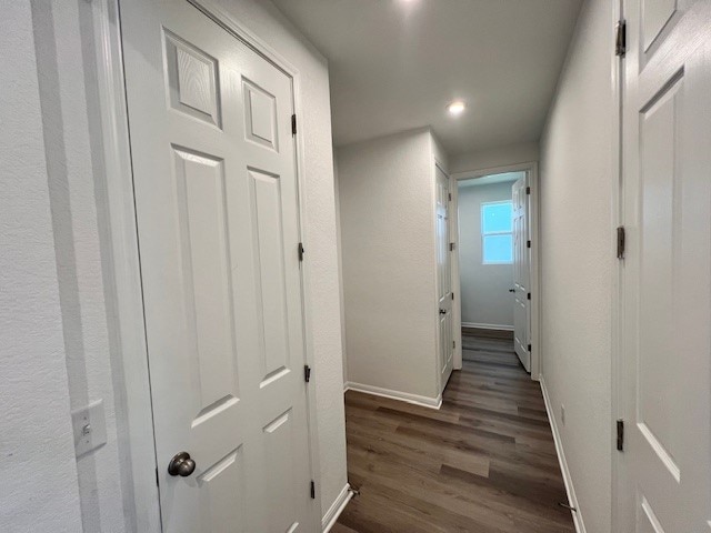 corridor with dark hardwood / wood-style flooring