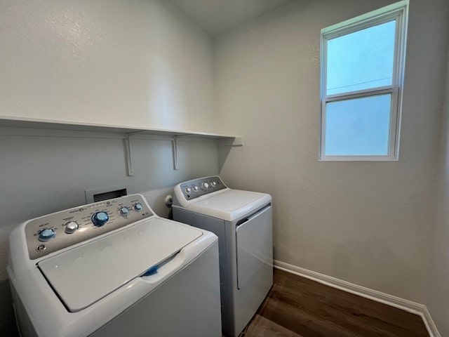 washroom with dark wood-type flooring and washer and clothes dryer