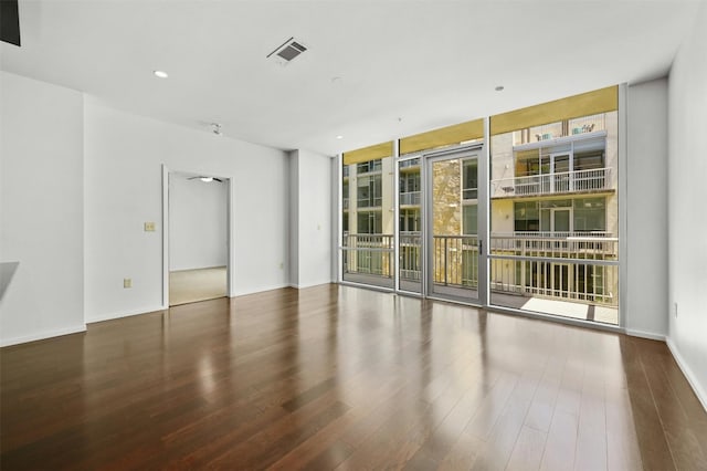 empty room with floor to ceiling windows and dark hardwood / wood-style floors