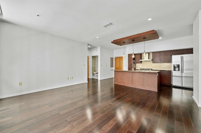 kitchen with sink, hanging light fixtures, stainless steel appliances, a center island with sink, and dark hardwood / wood-style flooring