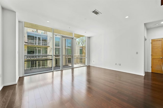 unfurnished room with a wall of windows and dark hardwood / wood-style flooring