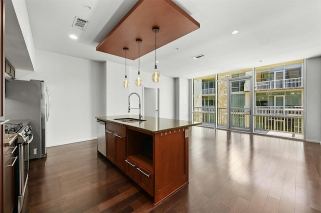 kitchen featuring dark hardwood / wood-style flooring, floor to ceiling windows, a kitchen island with sink, and sink