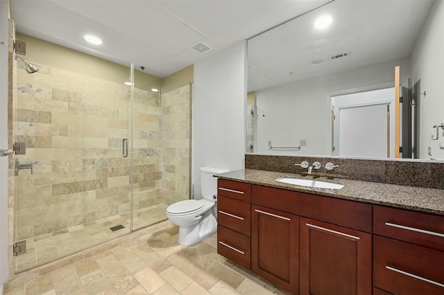 bathroom featuring vanity, toilet, and an enclosed shower