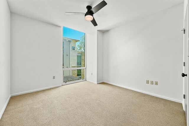 carpeted spare room with ceiling fan